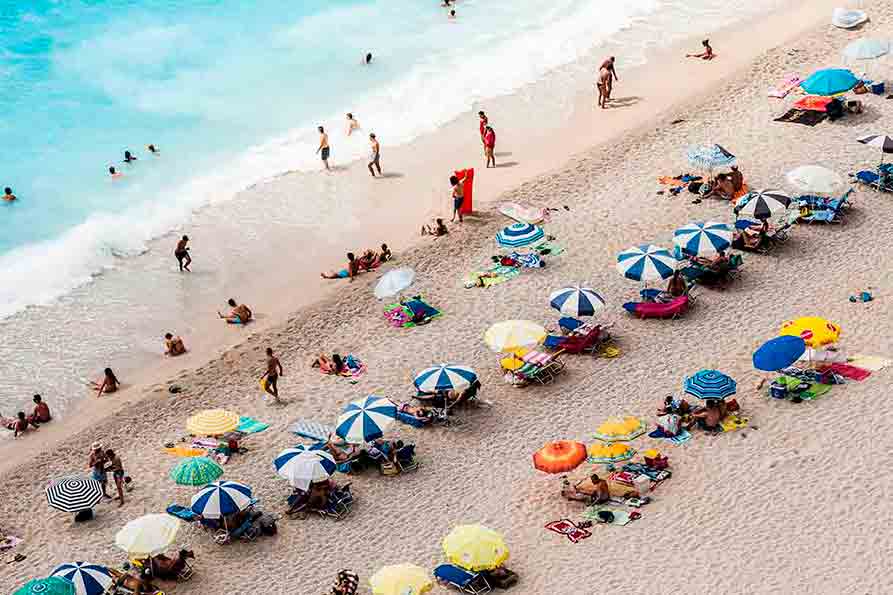 Turistas en la playa postcovid.