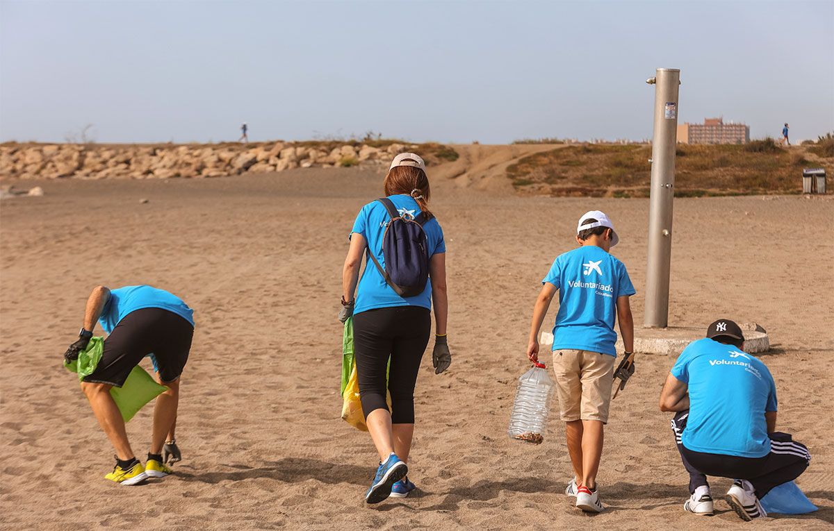 voluntarios CaixaBank recogiendo basura de las playas de Andalucía